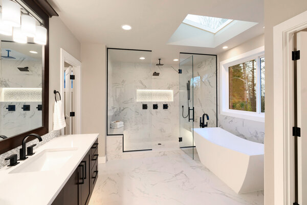 High end bathroom with white marble flood, free standing tub, and gorgeous walk in shower